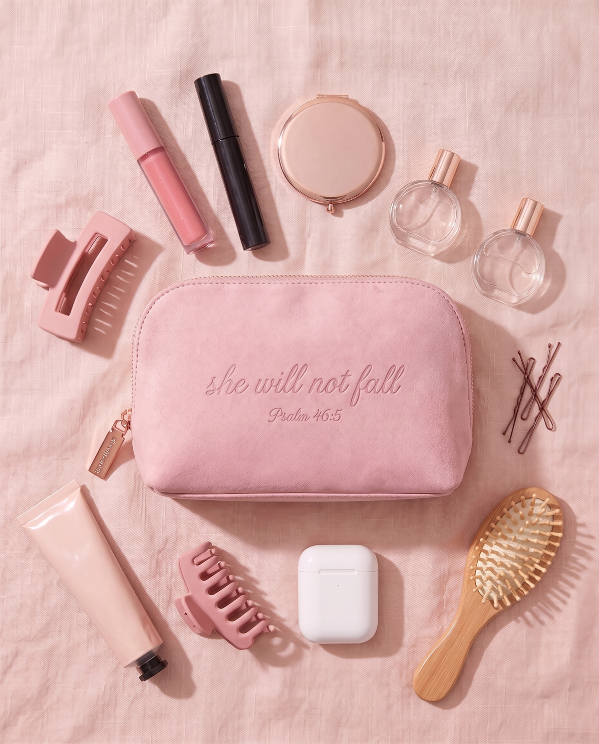 Everything that fits in the 46:5 Pouch: lip gloss, mascara, compact, perfume, hand cream, hair clips, earbuds and a brush